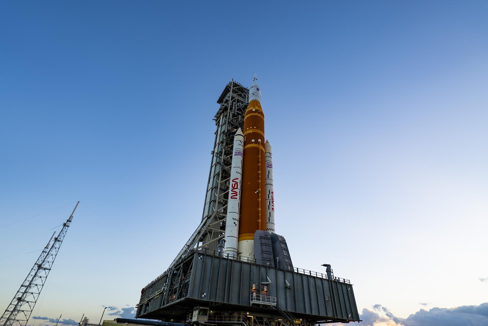 This image shows NASA’s SLS (Space Launch System) and Orion spacecraft rolling out of the Vehicle Assembly Building at NASA’s Kennedy Space Center. NASA's massive Crawler-Transporter, upgraded for the Artemis program, carries the powerful SLS rocket and Orion spacecraft on the Mobile Launcher from the Vehicle Assembly Building to Launch Pad 39B at Kennedy Space Center in preparation for the Artemis II mission.